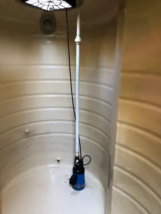 A White Pipe Is Hanging Inside Of A Water Tank — Alligator Water Tank Cleaning In Pomona, QLD