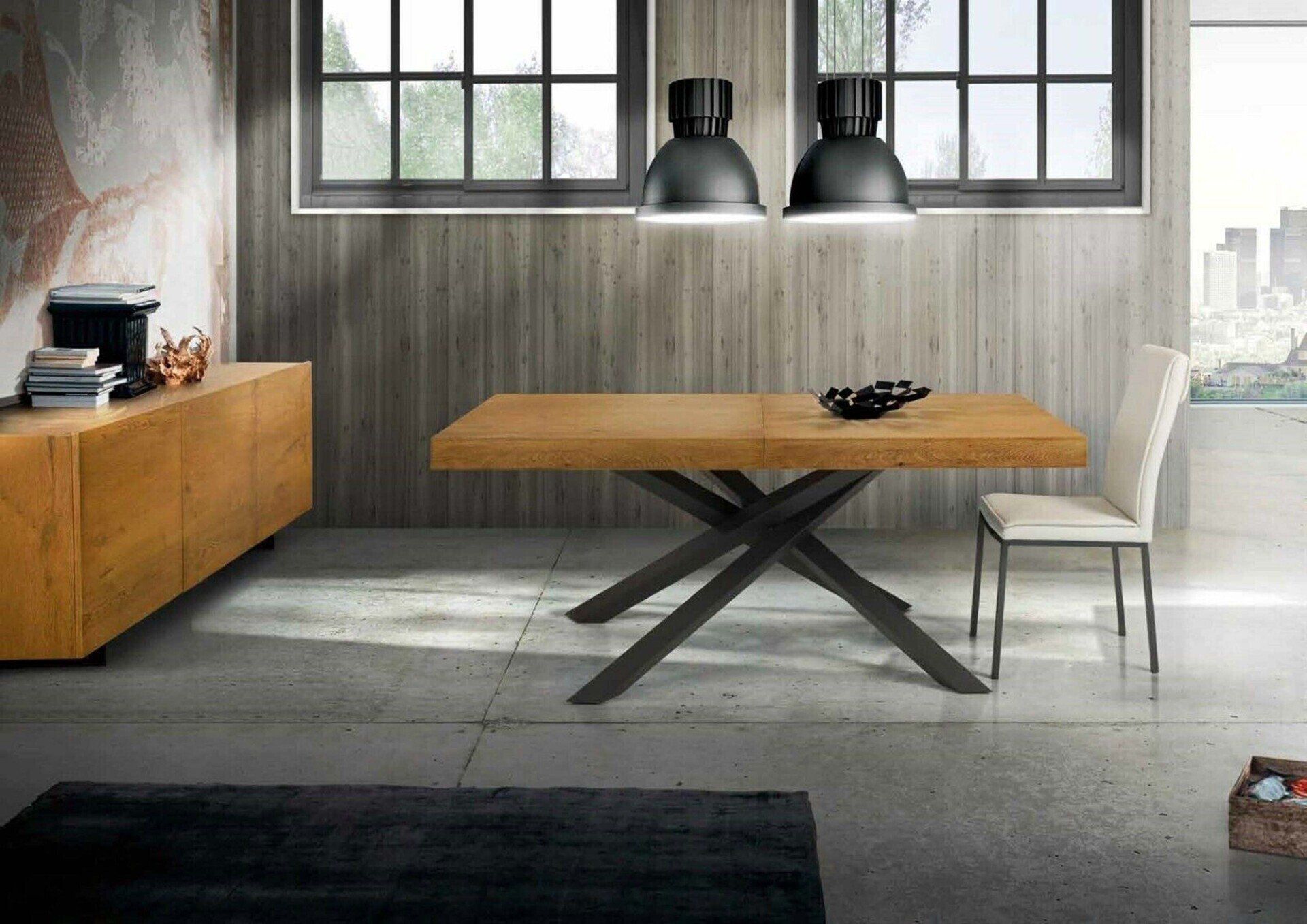 Moderna sala da pranzo con tavolo in legno, base in metallo scuro e lampade a sospensione.