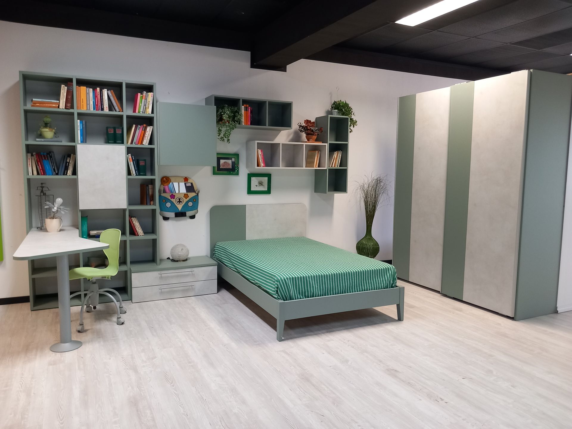 Set di mobili per la camera da letto: libreria grigia e verde, scrivania, letto, armadio.