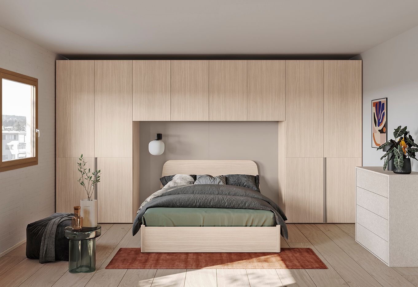 Camera da letto con letto posizionato al centro sotto armadi in legno, una finestra e una cassettiera laterale.