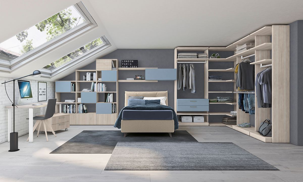 Camera da letto moderna con lucernari, spazio contenitore integrato, letto e zona studio. Legno chiaro e dettagli blu.