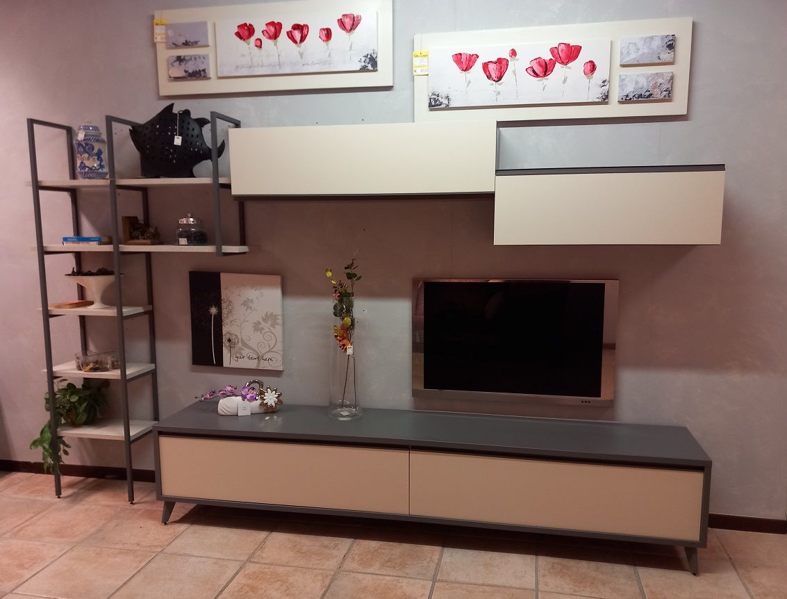 Parete attrezzata per soggiorno con mensole, TV e pezzi decorativi; tonalità crema e grigio.