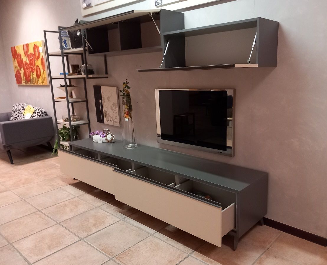 Soggiorno con mobile TV grigio e bianco, scaffali, TV e opere d'arte sul pavimento piastrellato.