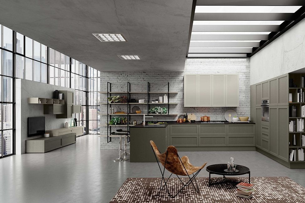 Moderna cucina a pianta aperta con mobili verde oliva, parete in mattoni a vista e zona soggiorno.