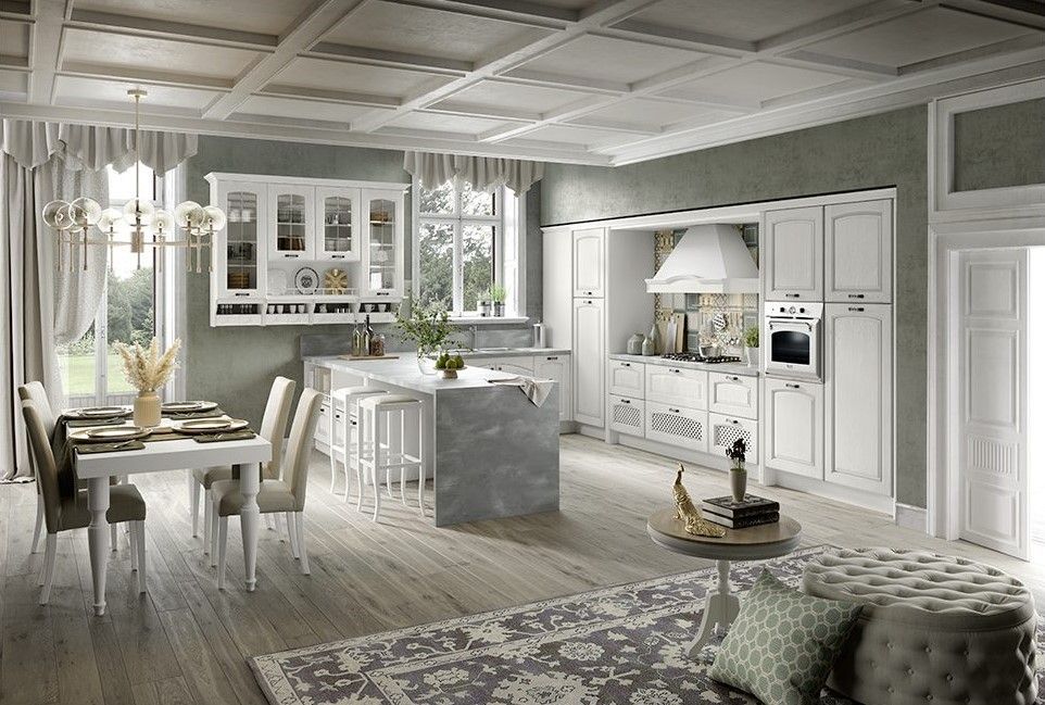Elegante cucina bianca con zona pranzo, isola e dettagli decorativi. Pavimenti in legno chiaro, pareti verdi e soffitto decorato.