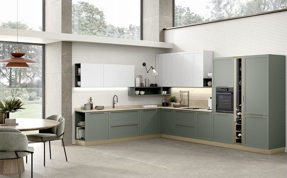 Cucina moderna con mobili verdi, pensili bianchi e tavolo da pranzo.