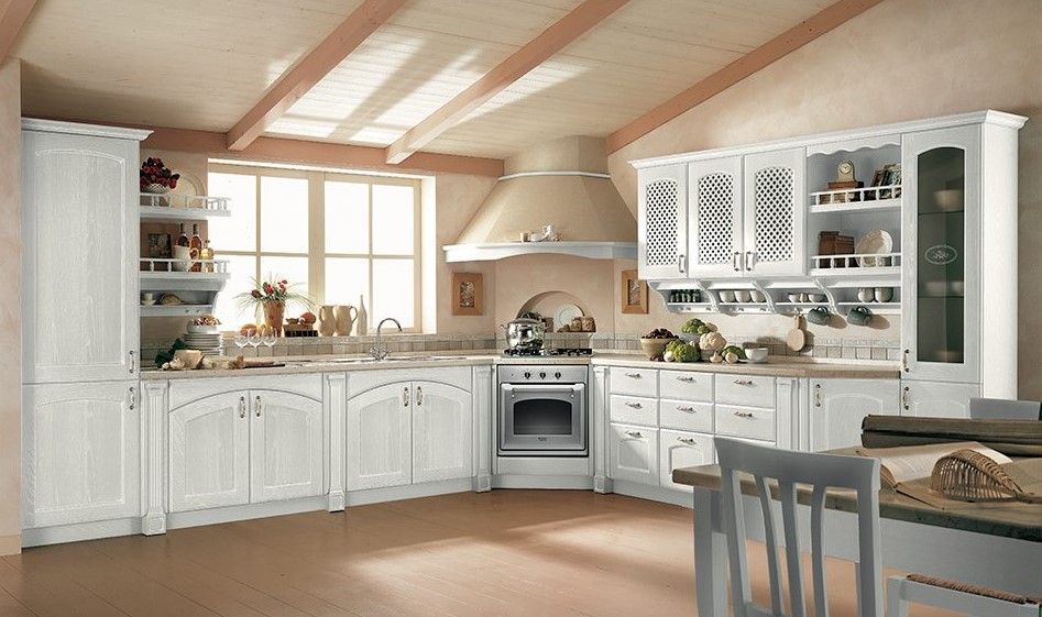 Cucina bianca con travi in legno, mobili ed elettrodomestici.