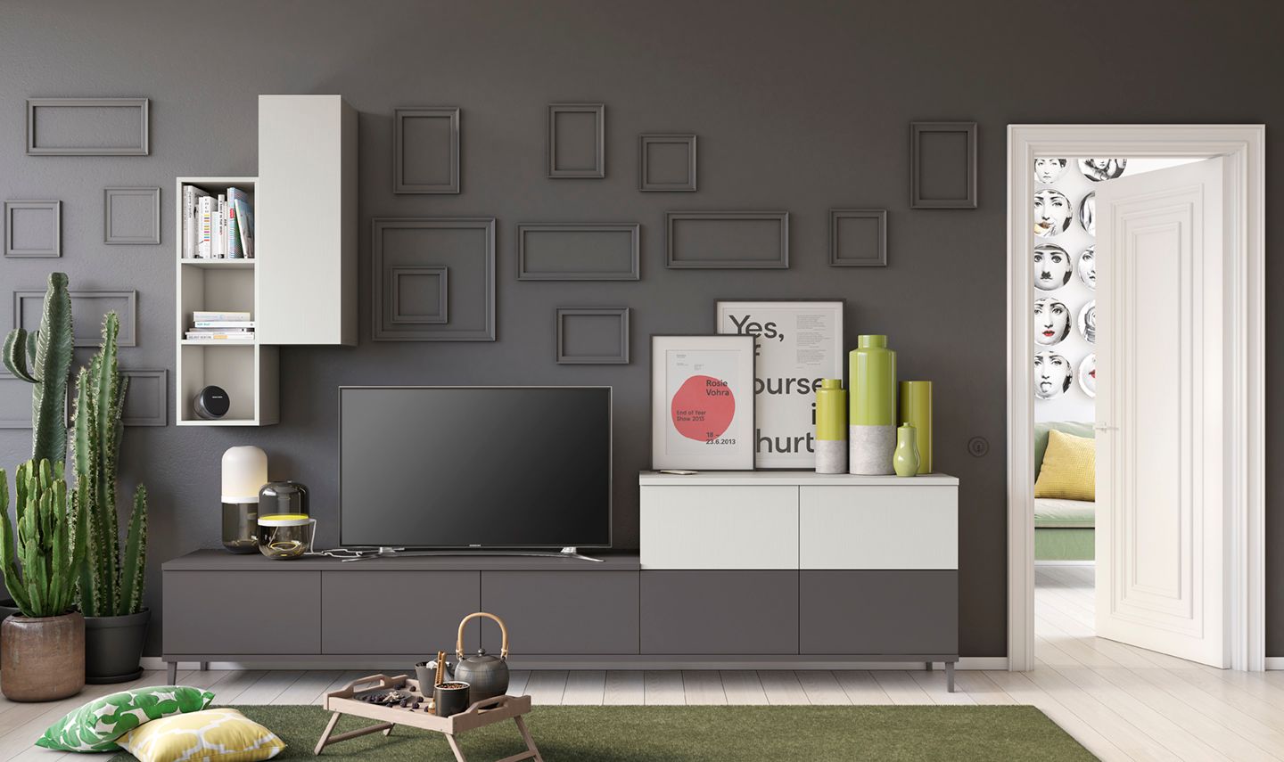 Soggiorno con mobili grigi e bianchi, TV e cornici decorative alle pareti. Dettagli verdi e cactus.