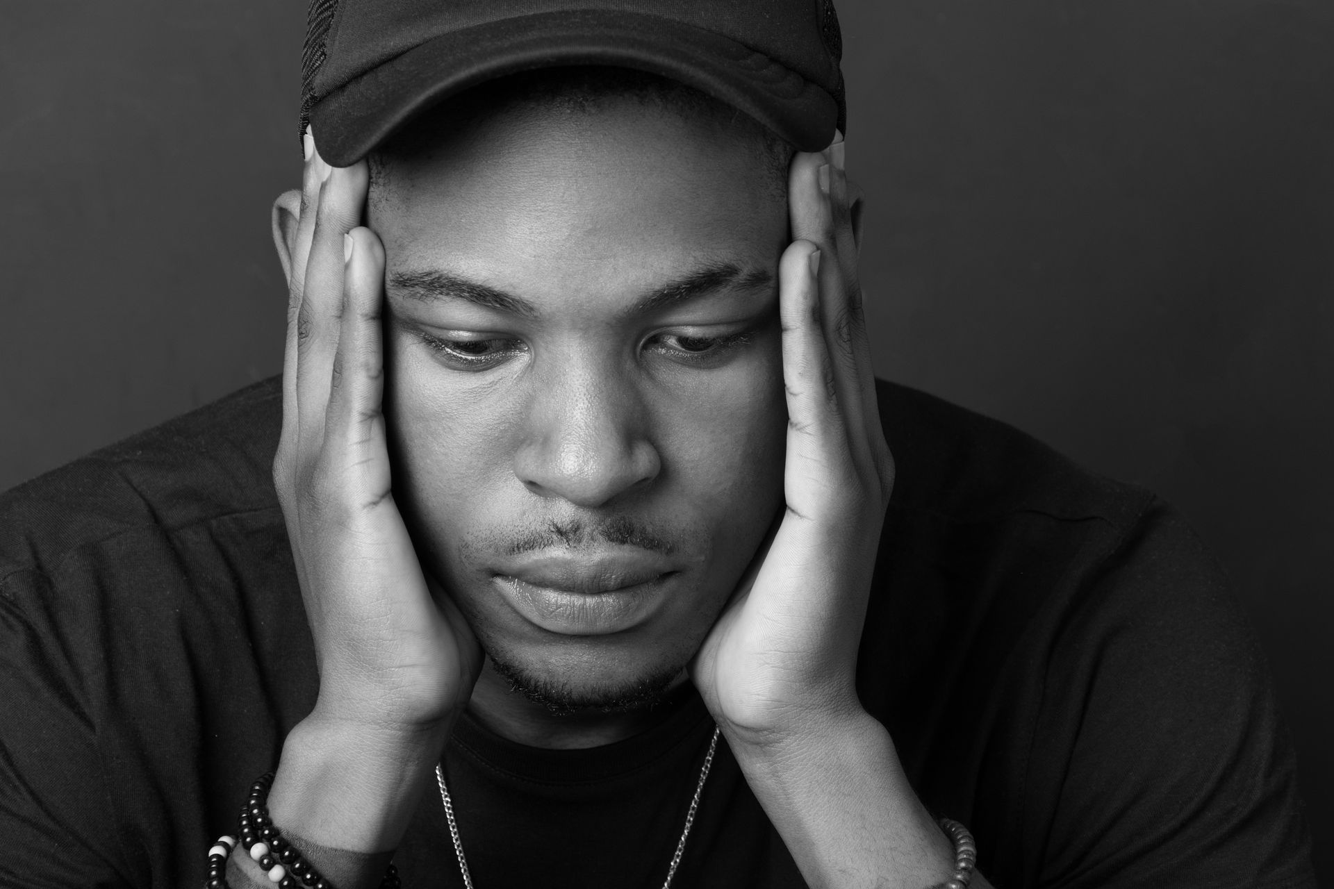 Black and white photo of a man holding his face - Atlanta, GA - Progressive Growth Coaching