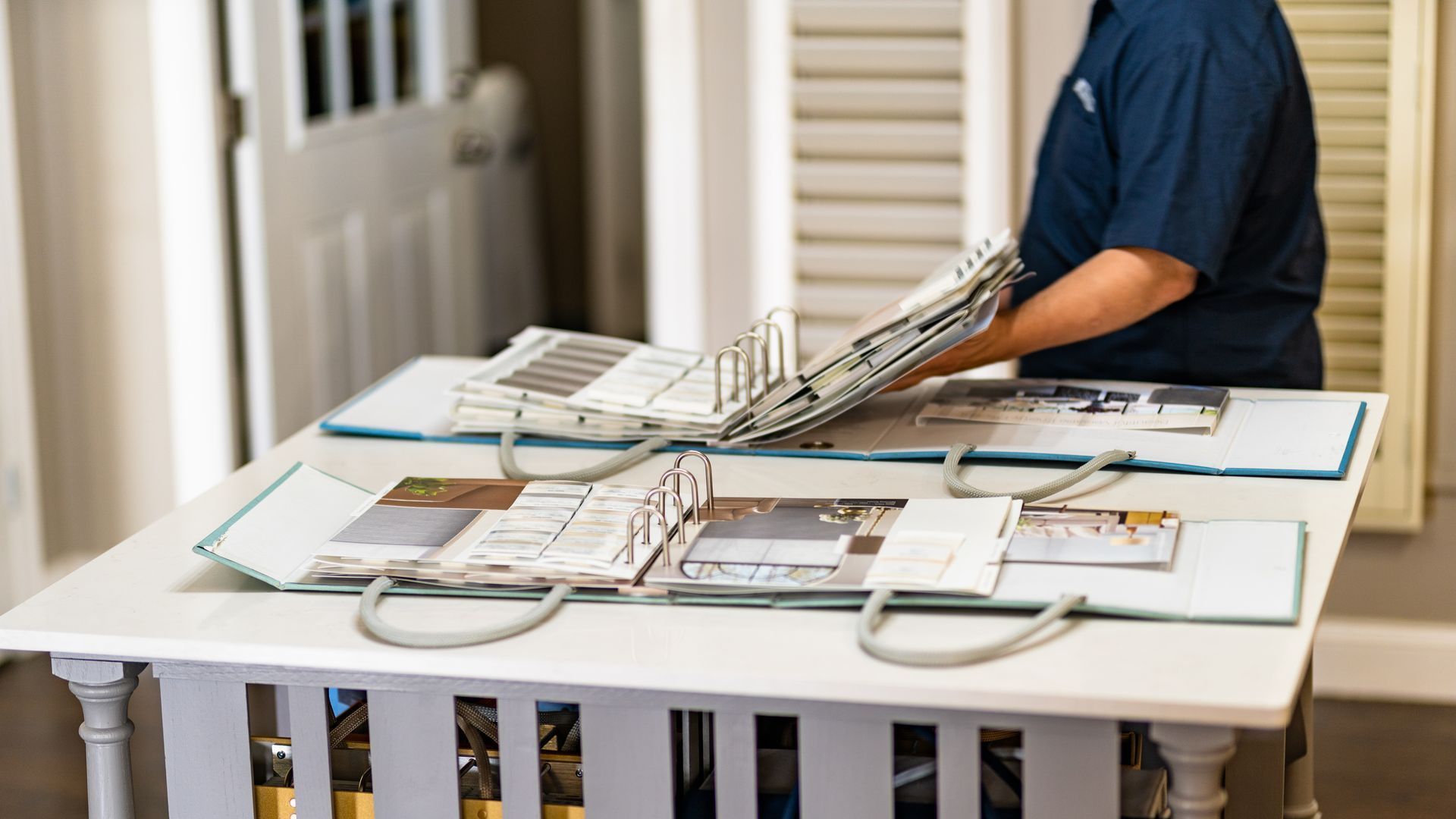 A man looking at Hunter Douglas catalogs at the Blind & Shutter Gallery near Thompson's Station, TN