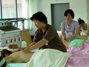 A woman is giving a man a massage in a room.