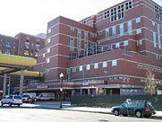 A large brick building with cars parked in front of it.