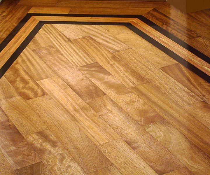 Pavimento in legno con bordo angolato. Il pavimento è marrone chiaro con bordo marrone scuro.