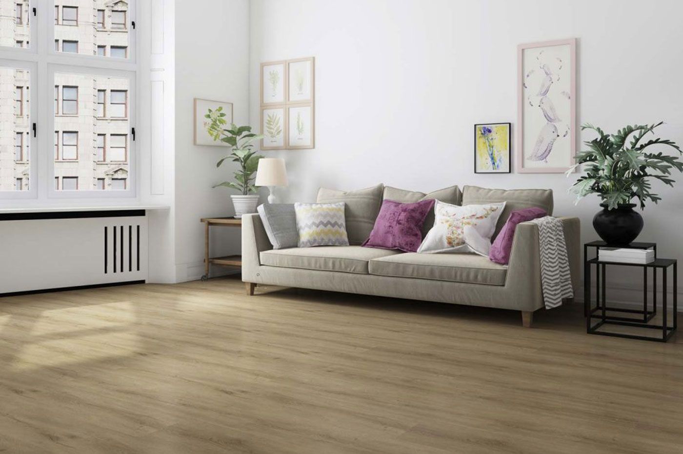 Soggiorno con pavimenti in legno, divano beige con cuscini colorati, opere d'arte, piante e una grande finestra.