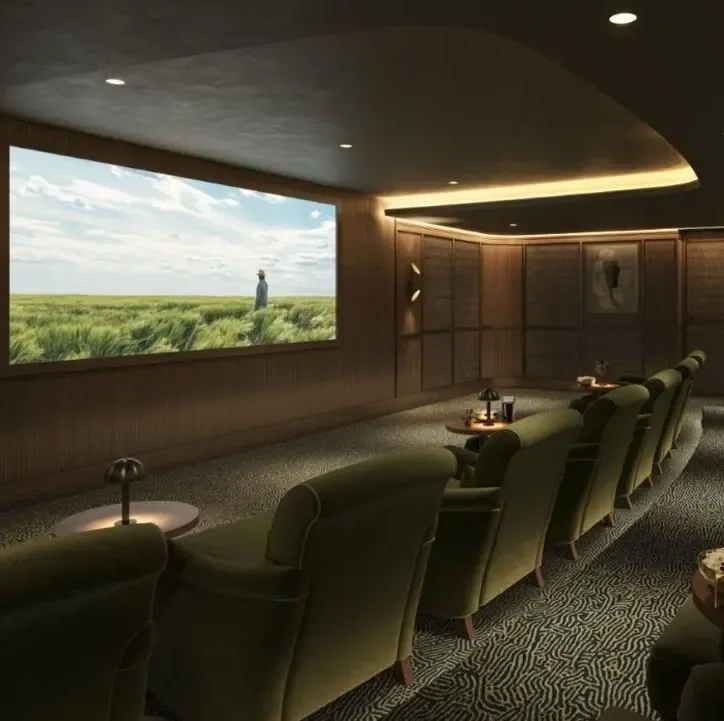 Dark home theater lounge with green recliners and a large screen showing a person in a grassy landscape