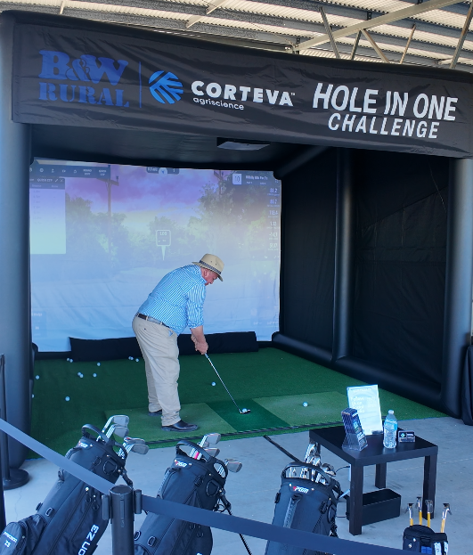 Man golfing in a brand sponsored golf simulator challenge with Mobile Golf Co.