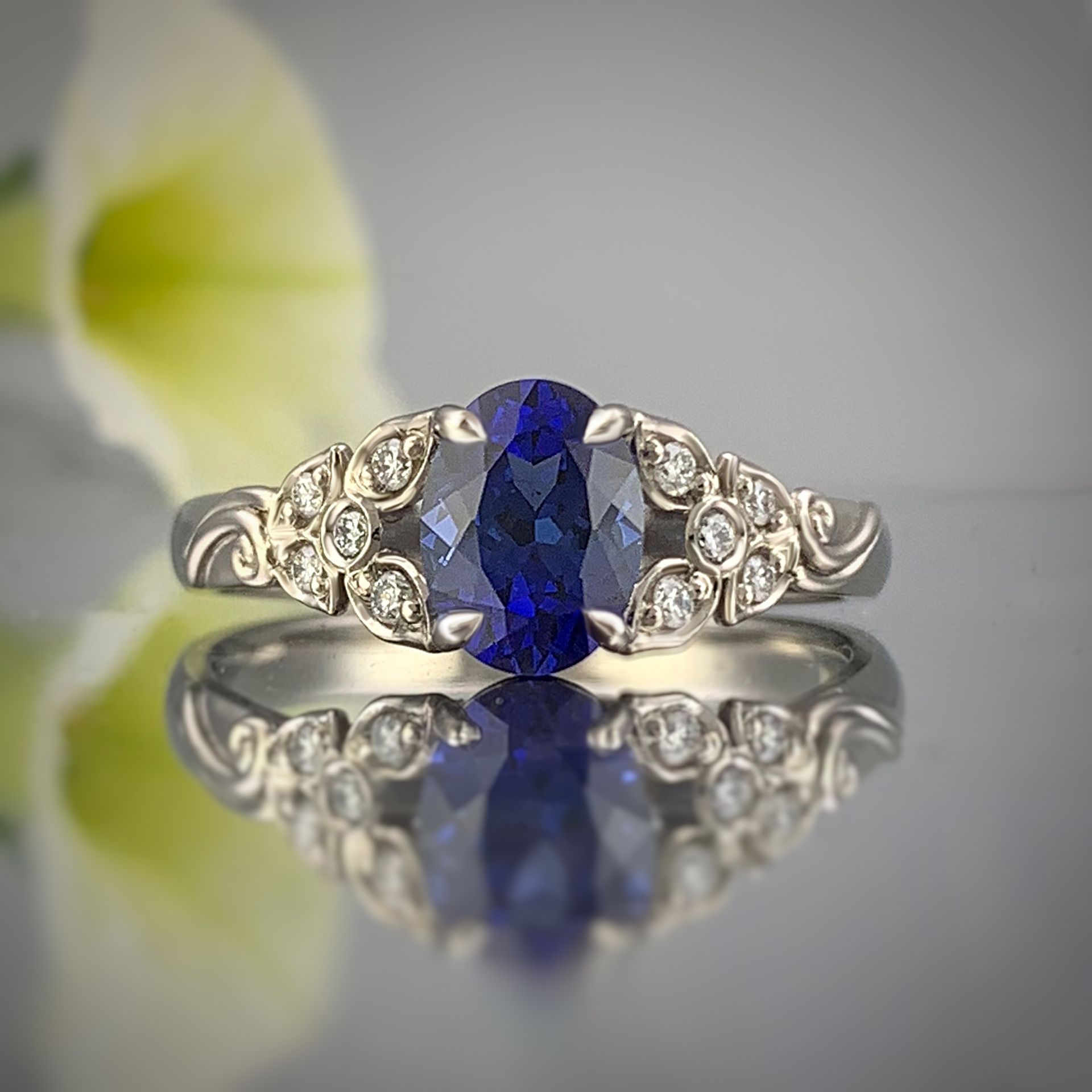 A ring with a sapphire and diamonds is sitting on a table.