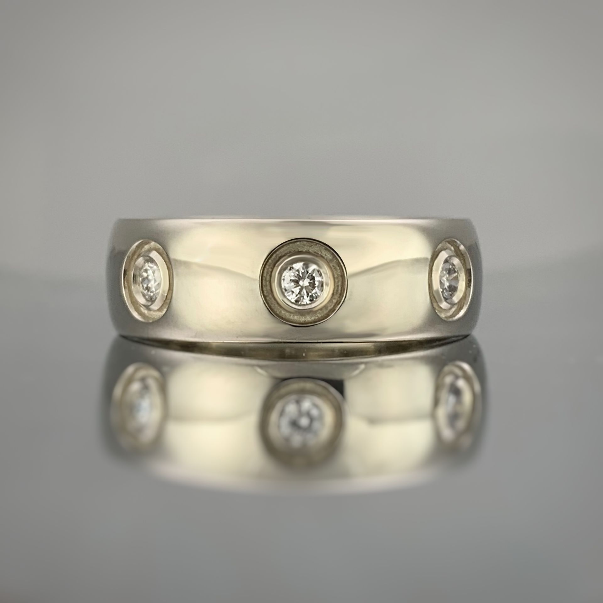 A gold ring with diamonds on it is sitting on a table.