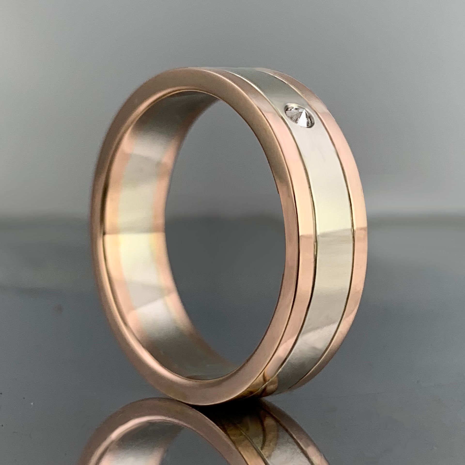 A gold and silver ring with a diamond in the center