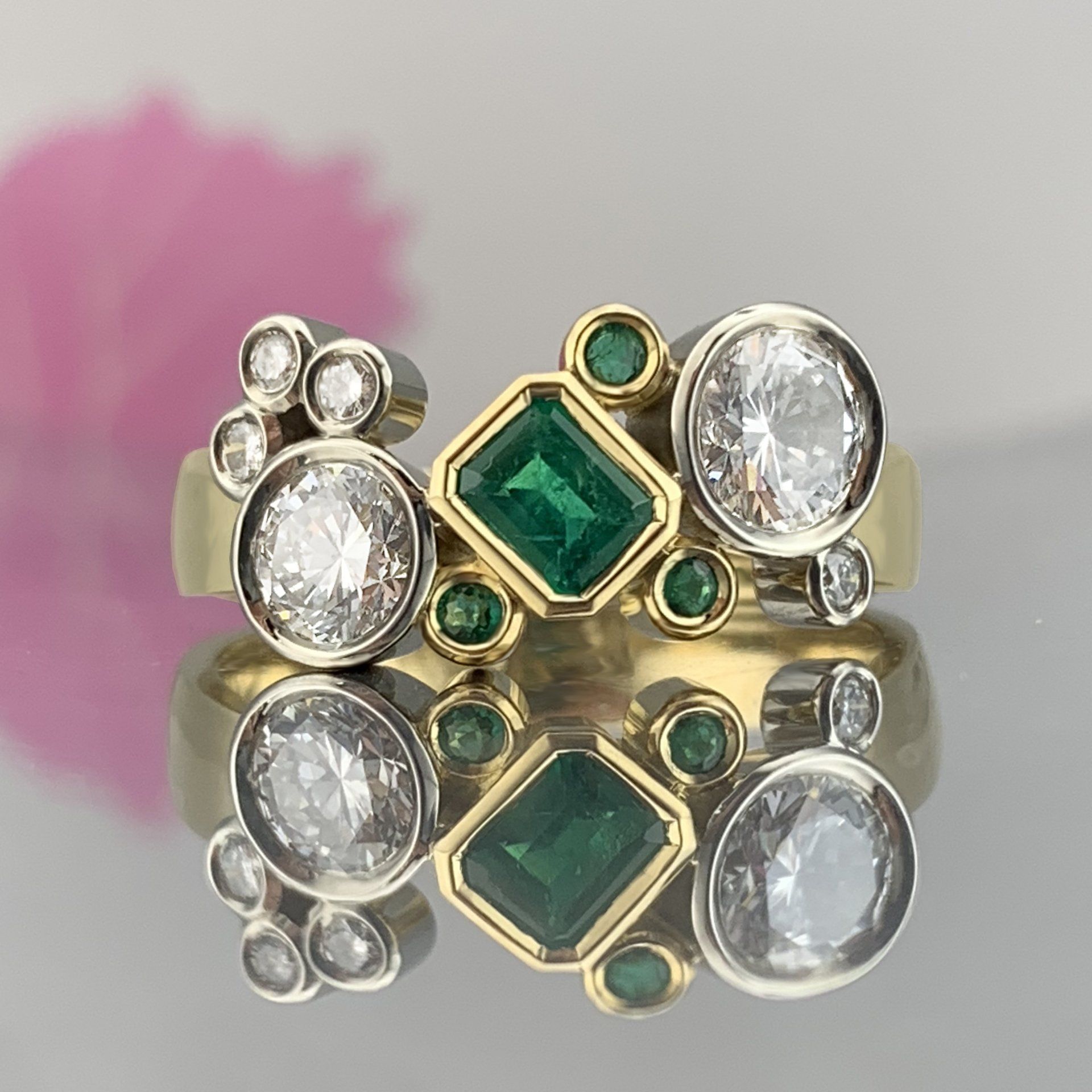 A yellow gold ring with emeralds and diamonds