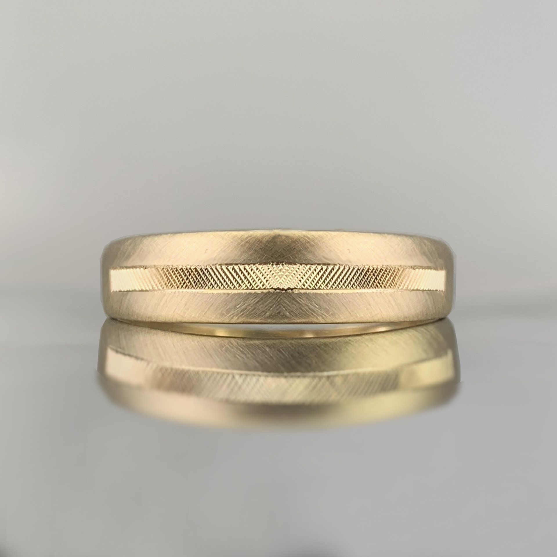 A close up of a gold wedding band on a table.