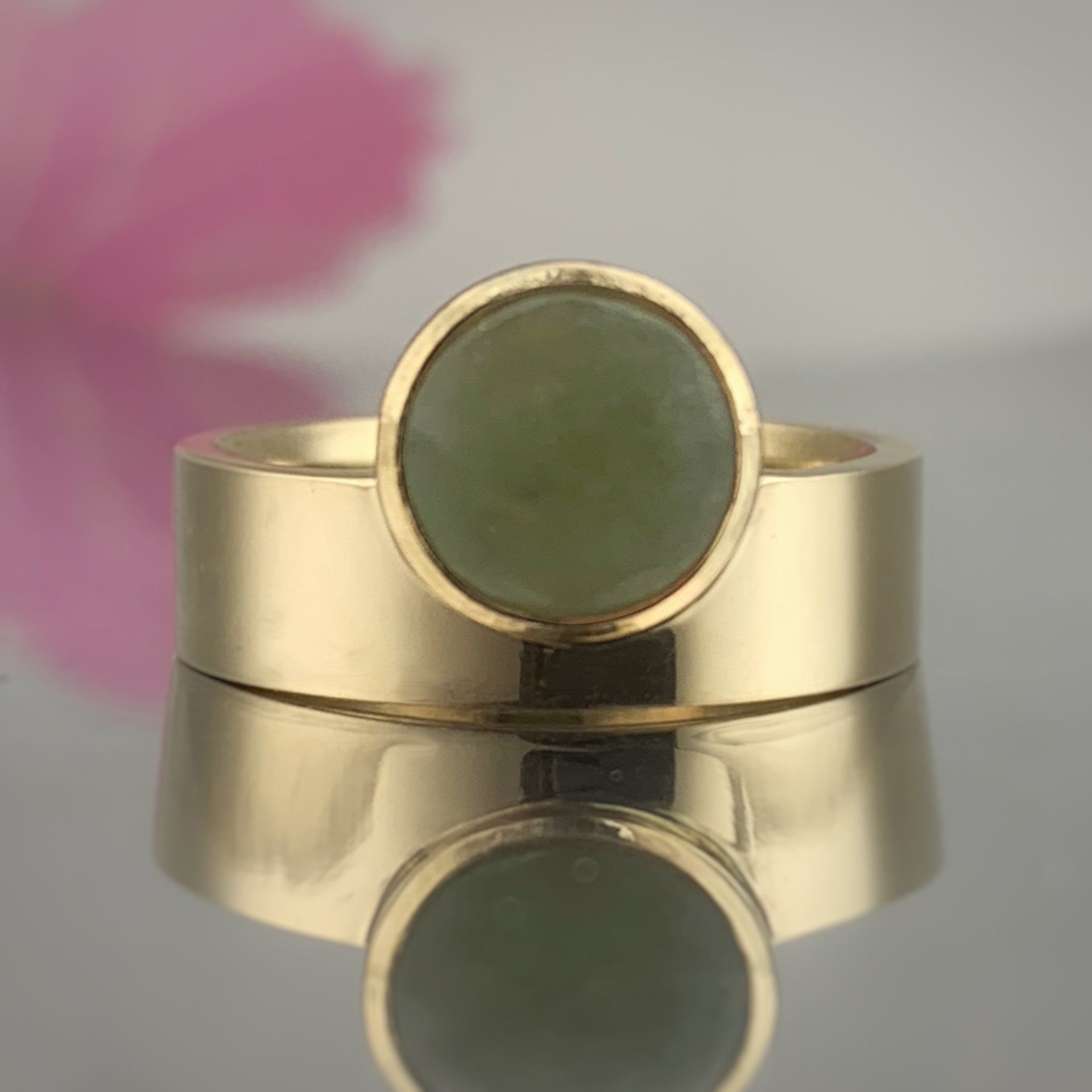 A gold ring with a green stone in the center