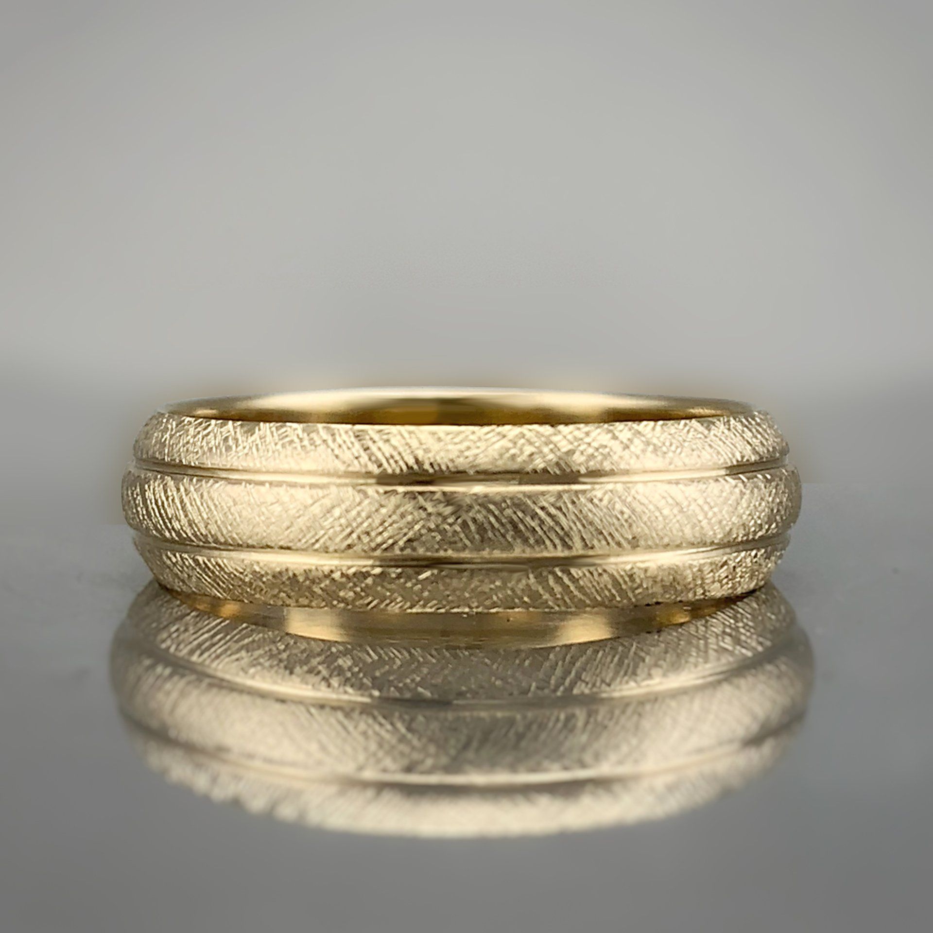 A close up of a gold ring on a table.
