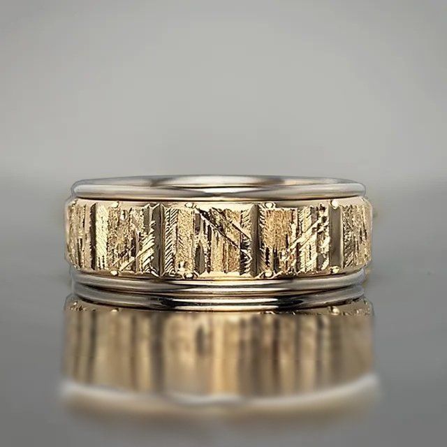 A close up of a gold ring on a table.
