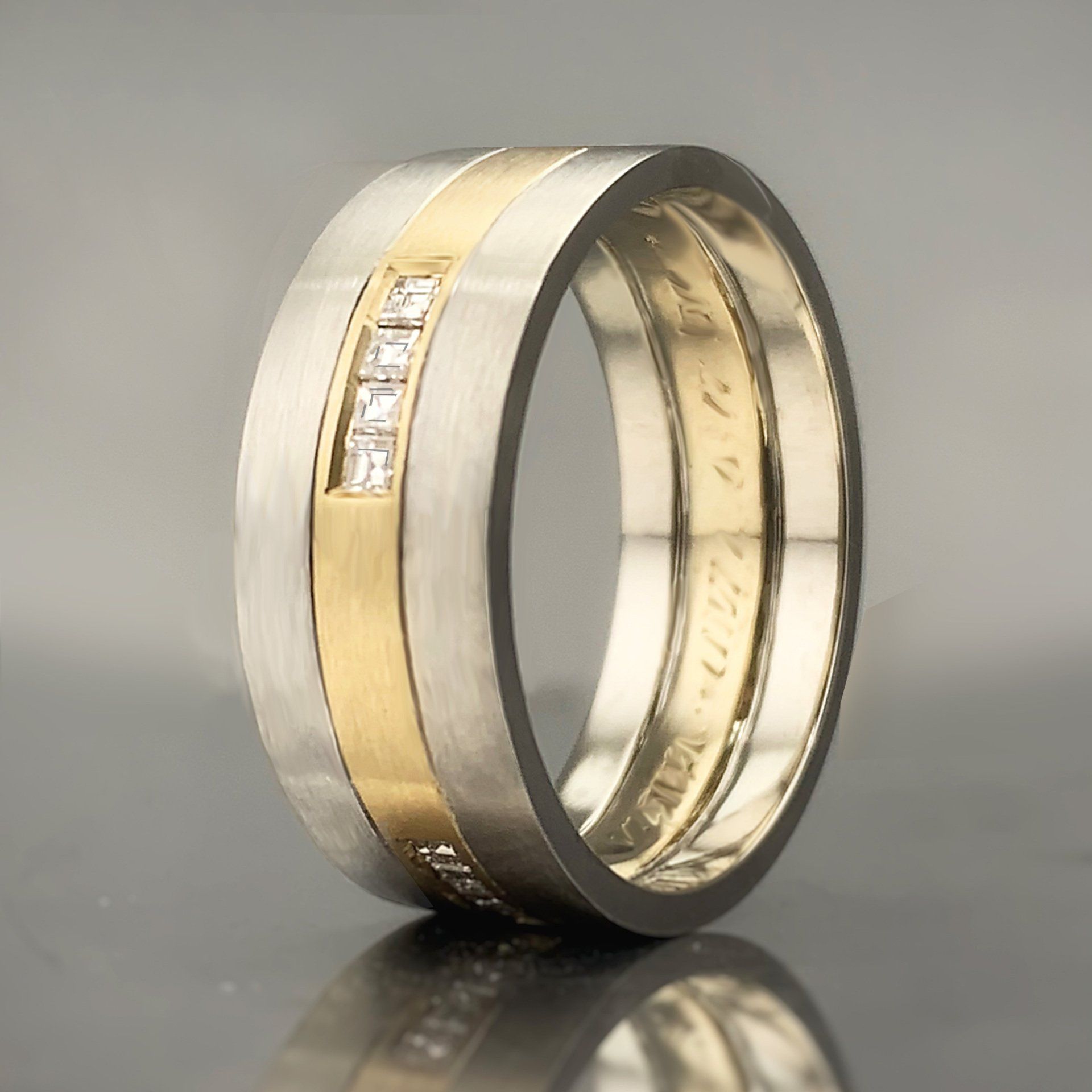 A silver and gold ring with diamonds on it