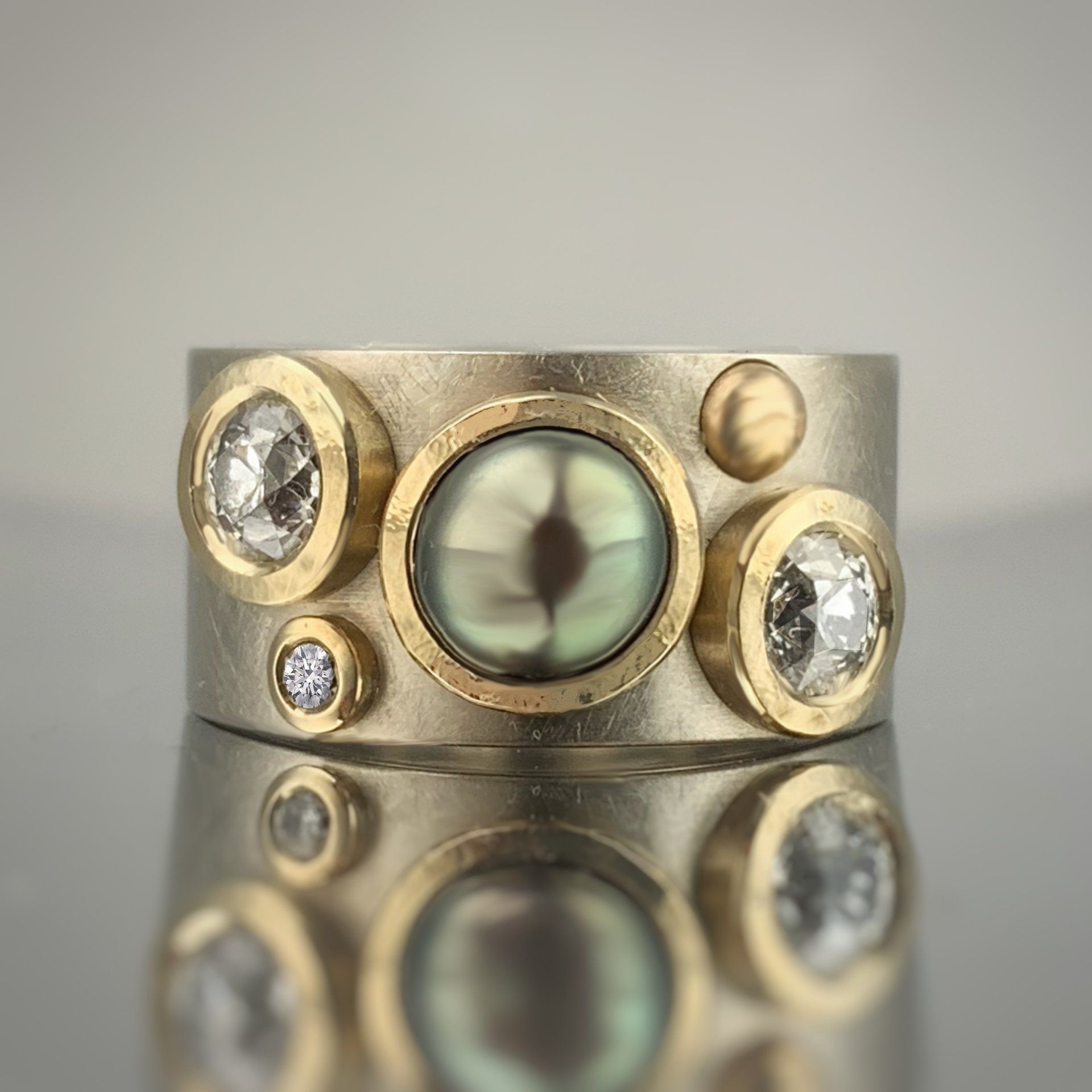A gold ring with diamonds and a green stone in the center