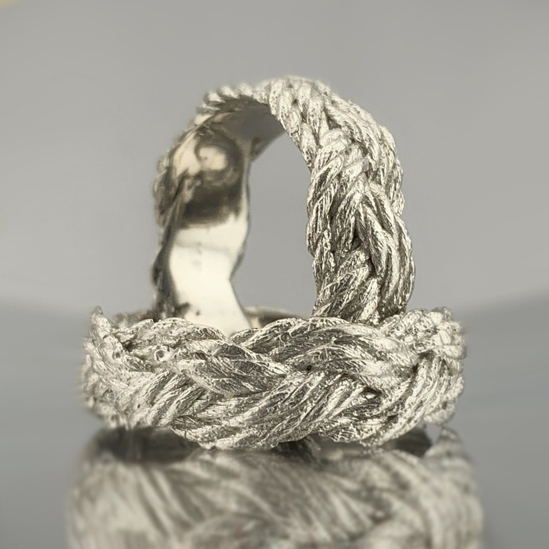 Two silver rings are sitting on top of each other on a table.
