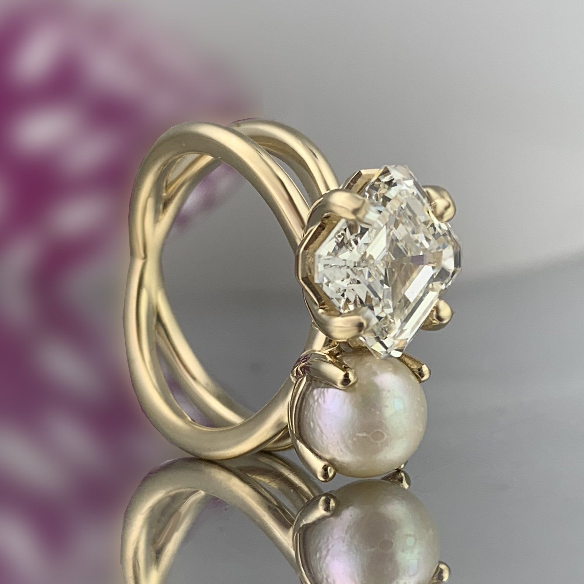 A gold ring with a diamond and a pearl