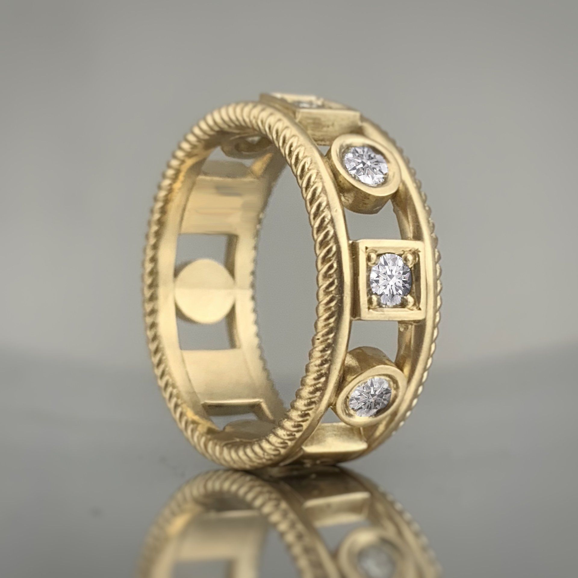A gold ring with diamonds on it is sitting on a table.