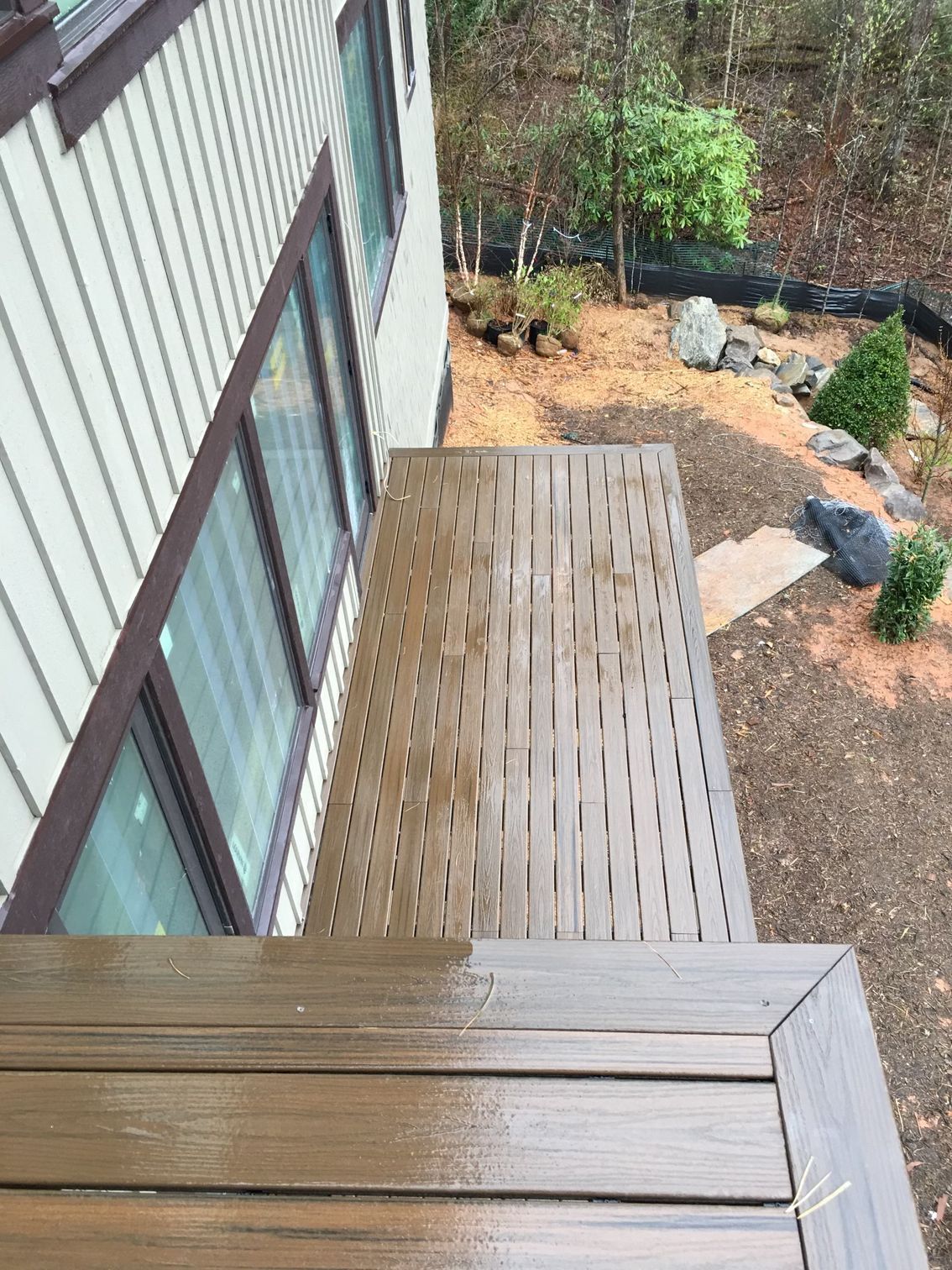 A house with a wooden deck and stairs in front of it.
