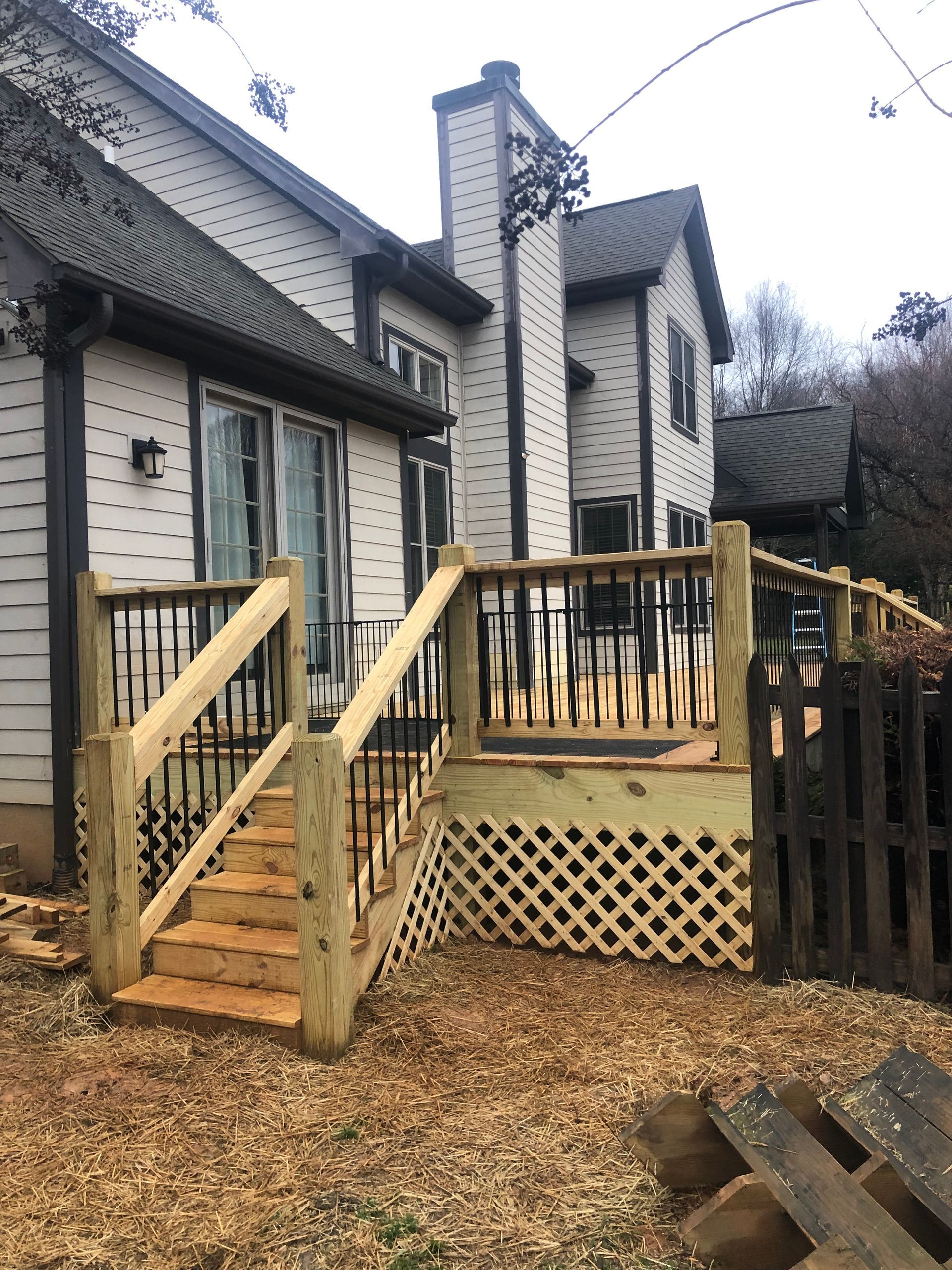 A house with a wooden deck and stairs in front of it.