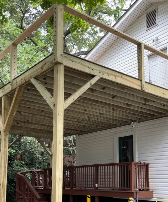A white house with a wooden deck in front of it