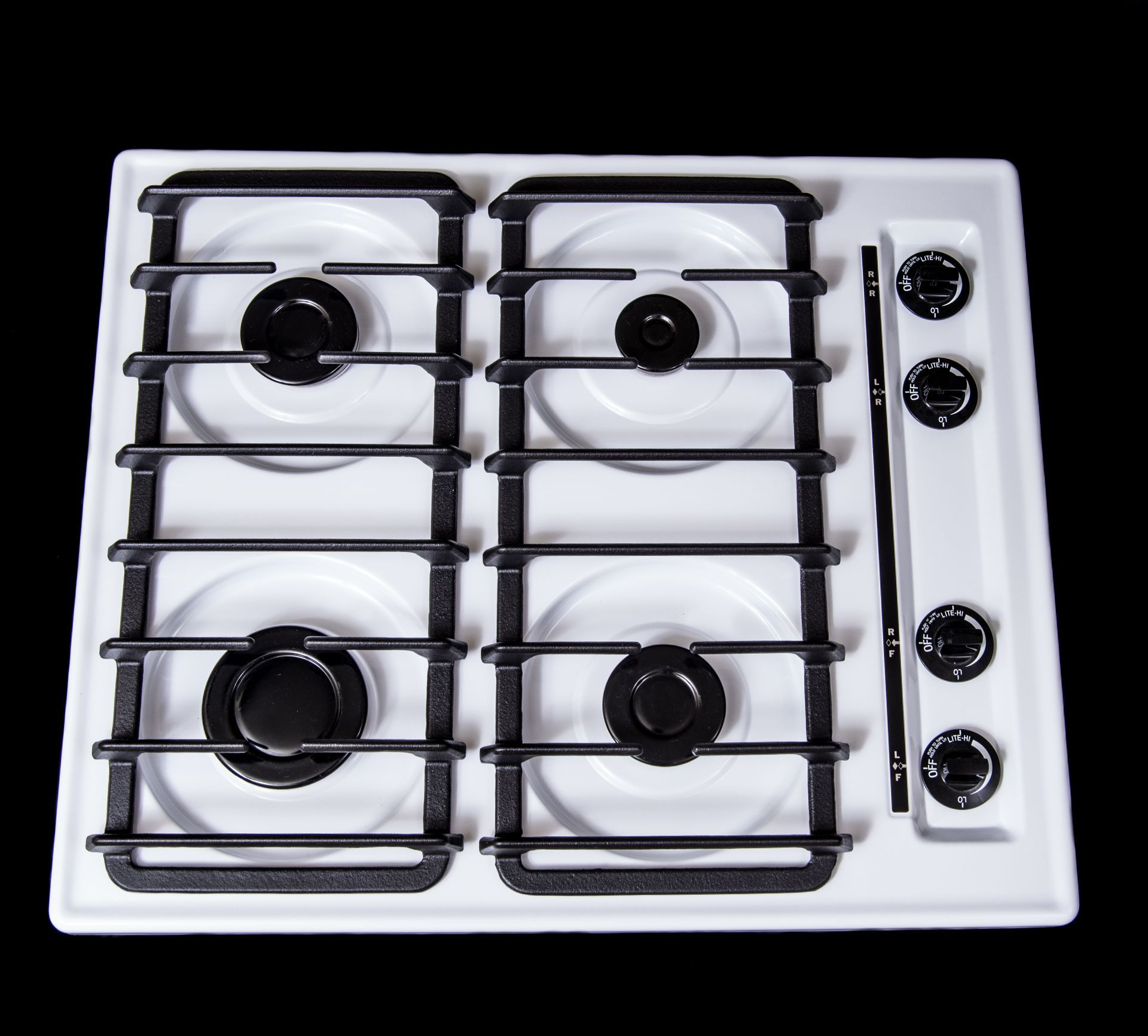 A white stove top with black burners and knobs
