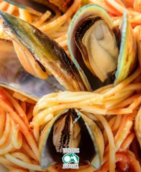 Spaghetti conditi con cozze aperte in salsa di pomodoro (primo piano)
