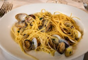 Piatto di spaghetti alle vongole in salsa leggera su un piatto bianco