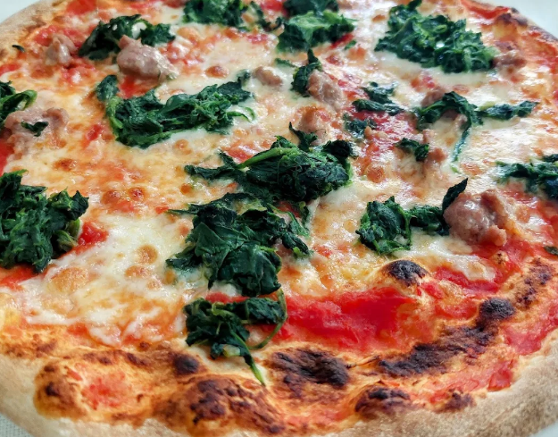 Pizza Margherita con formaggio fuso, salsa di pomodoro e foglie di basilico fresco.