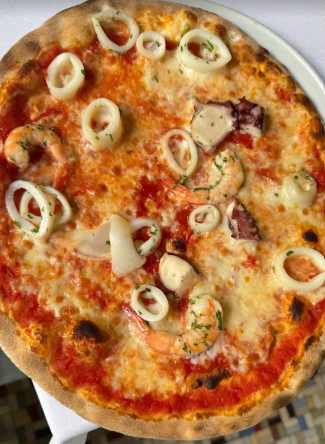 Pizza con anelli di calamari su un piatto bianco