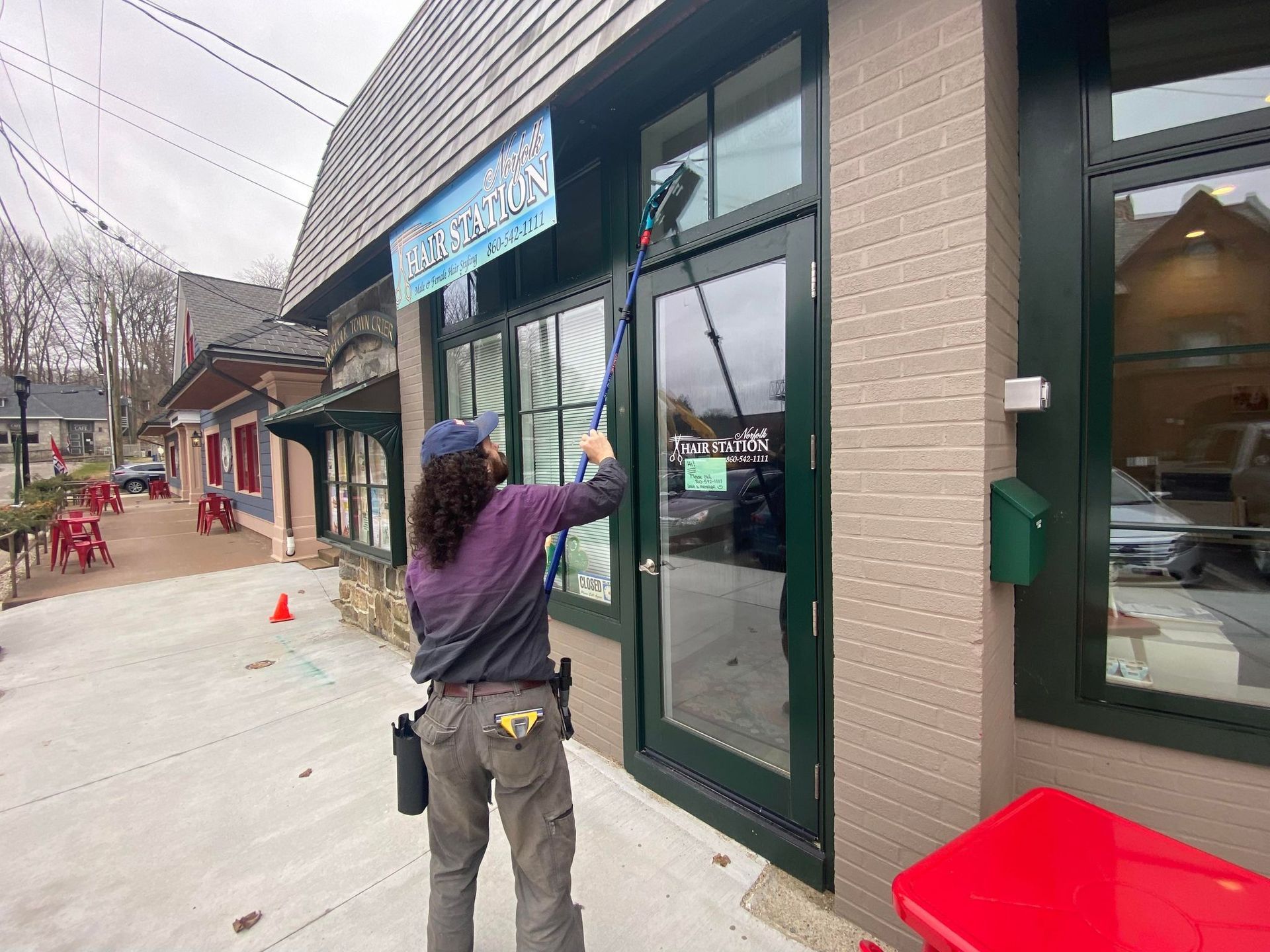 A woman is cleaning the windows of a building.