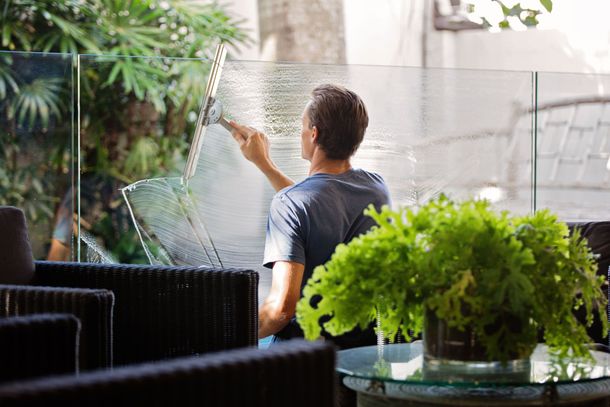 A man is cleaning a window with a squeegee.