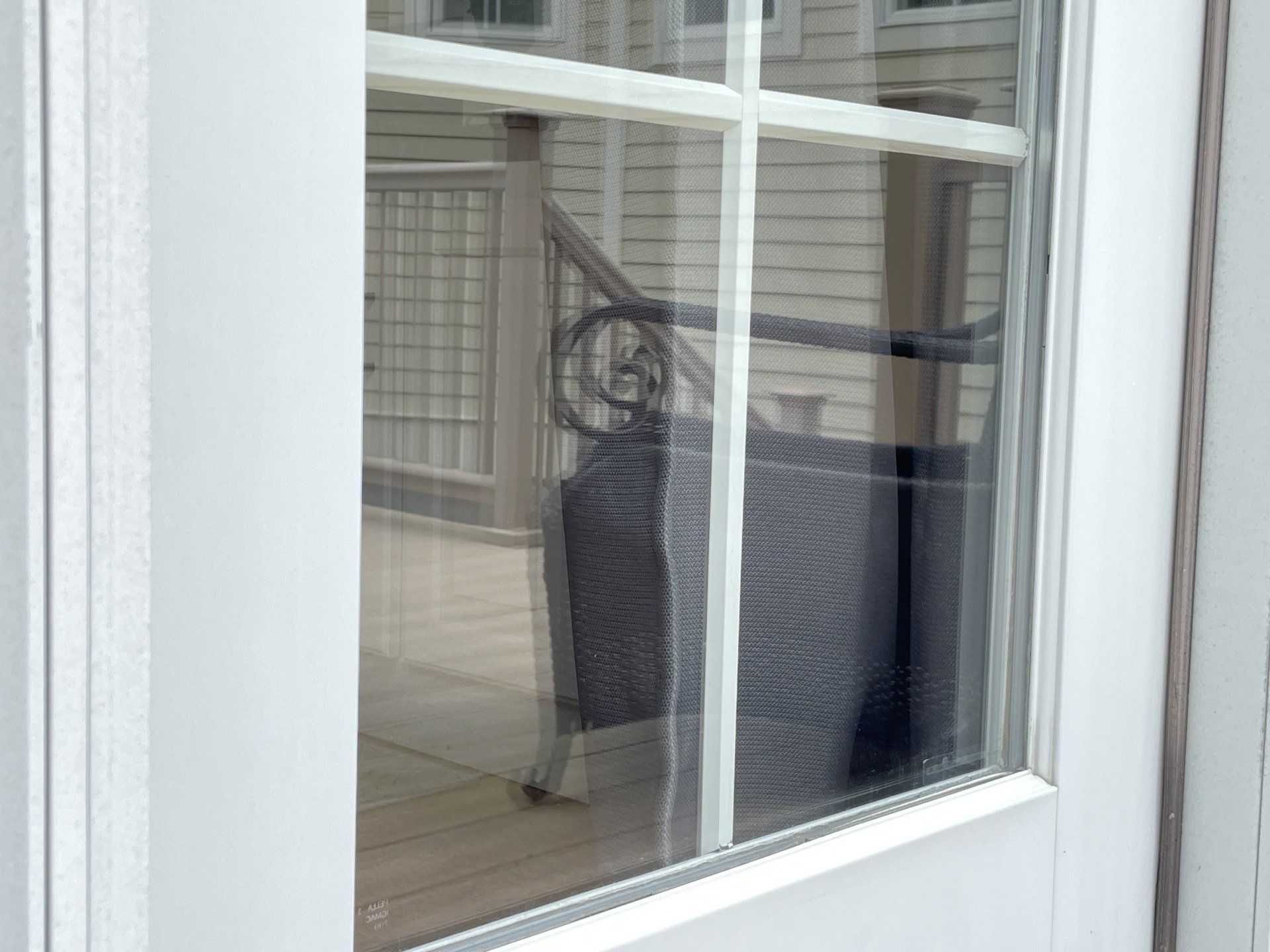 A white door with a reflection of a staircase in the window