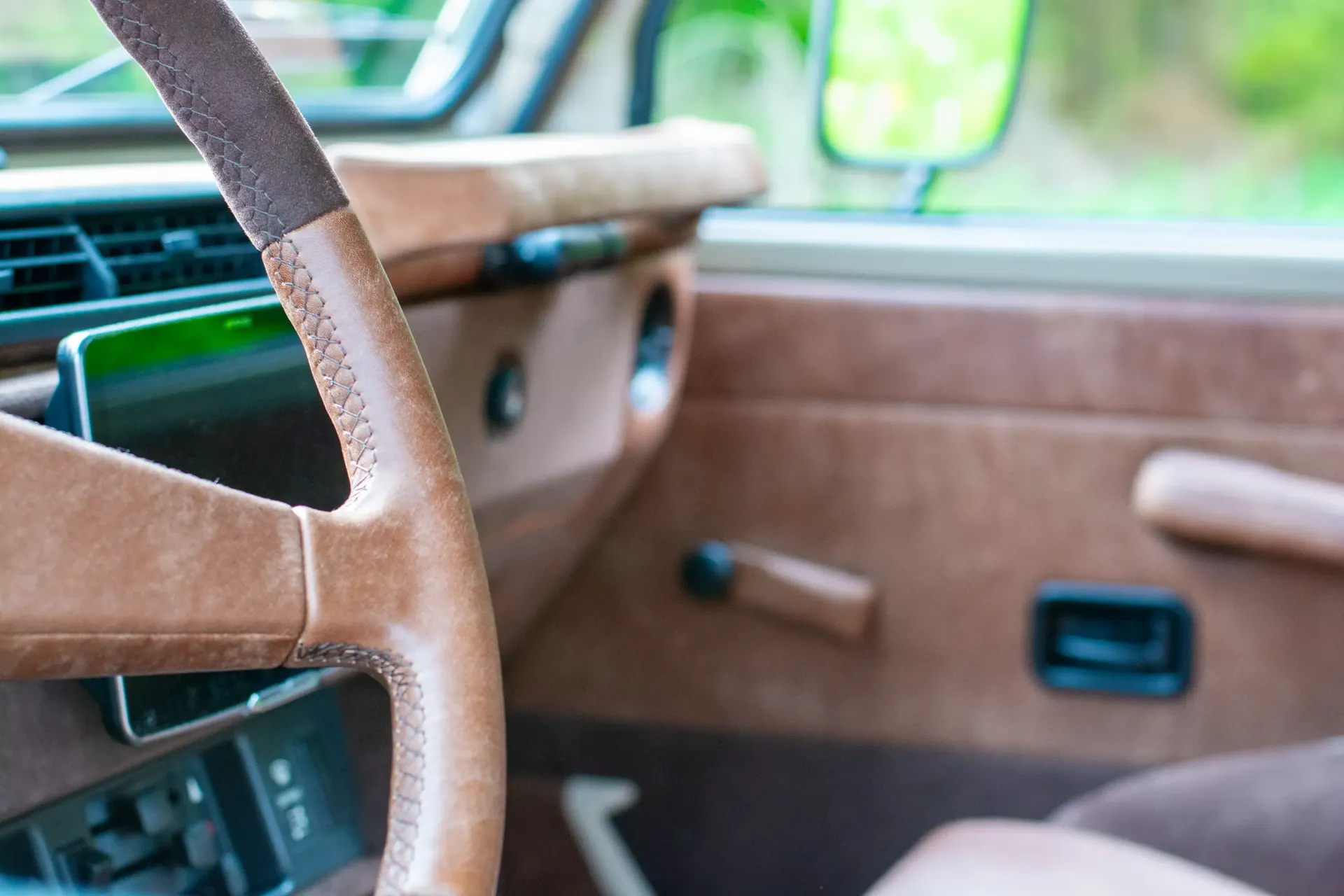 A close up of a brown leather steering wheel in a car, G-Wagon interior