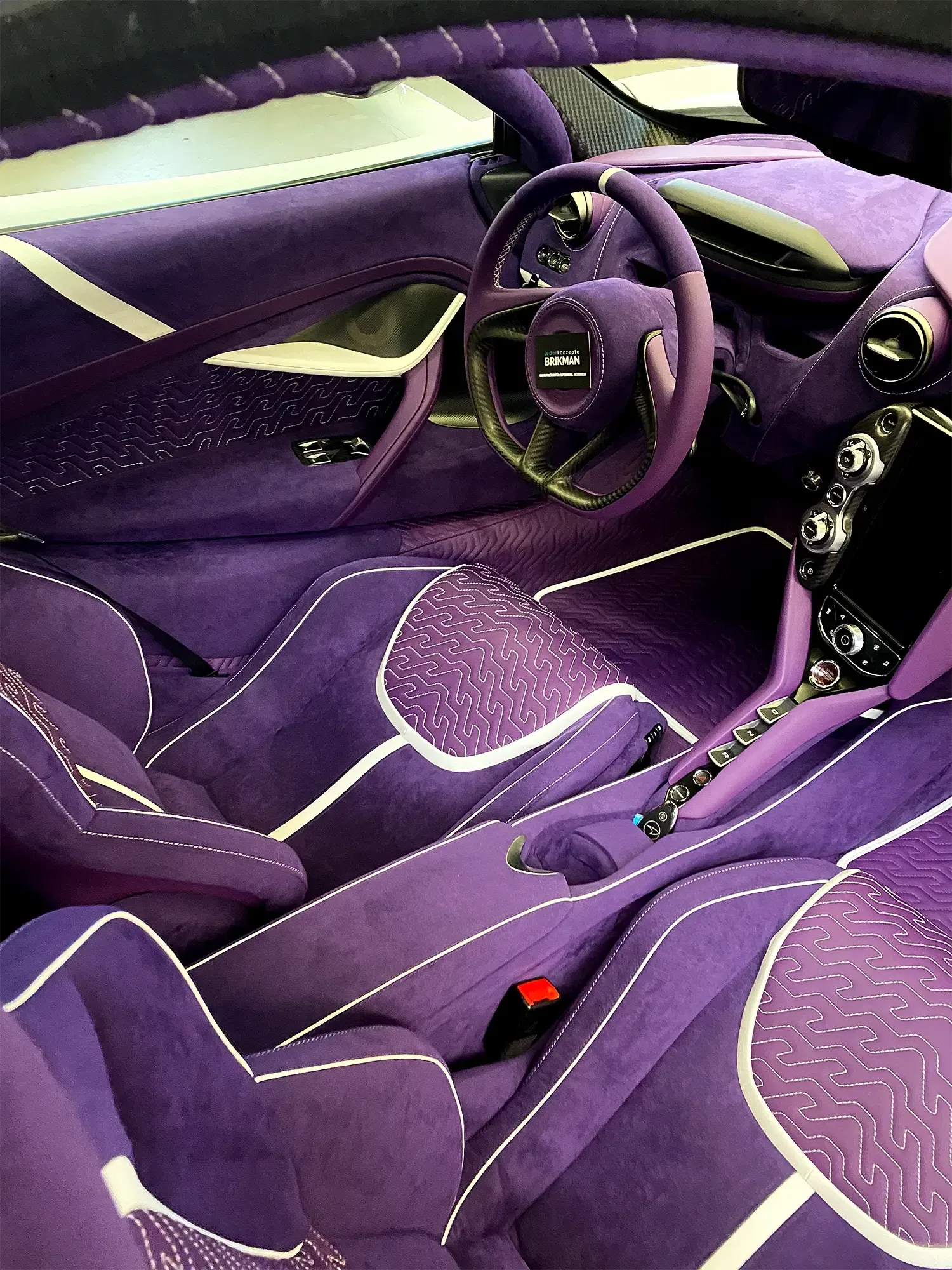 The interior of a purple car with a steering wheel, McLaren interior