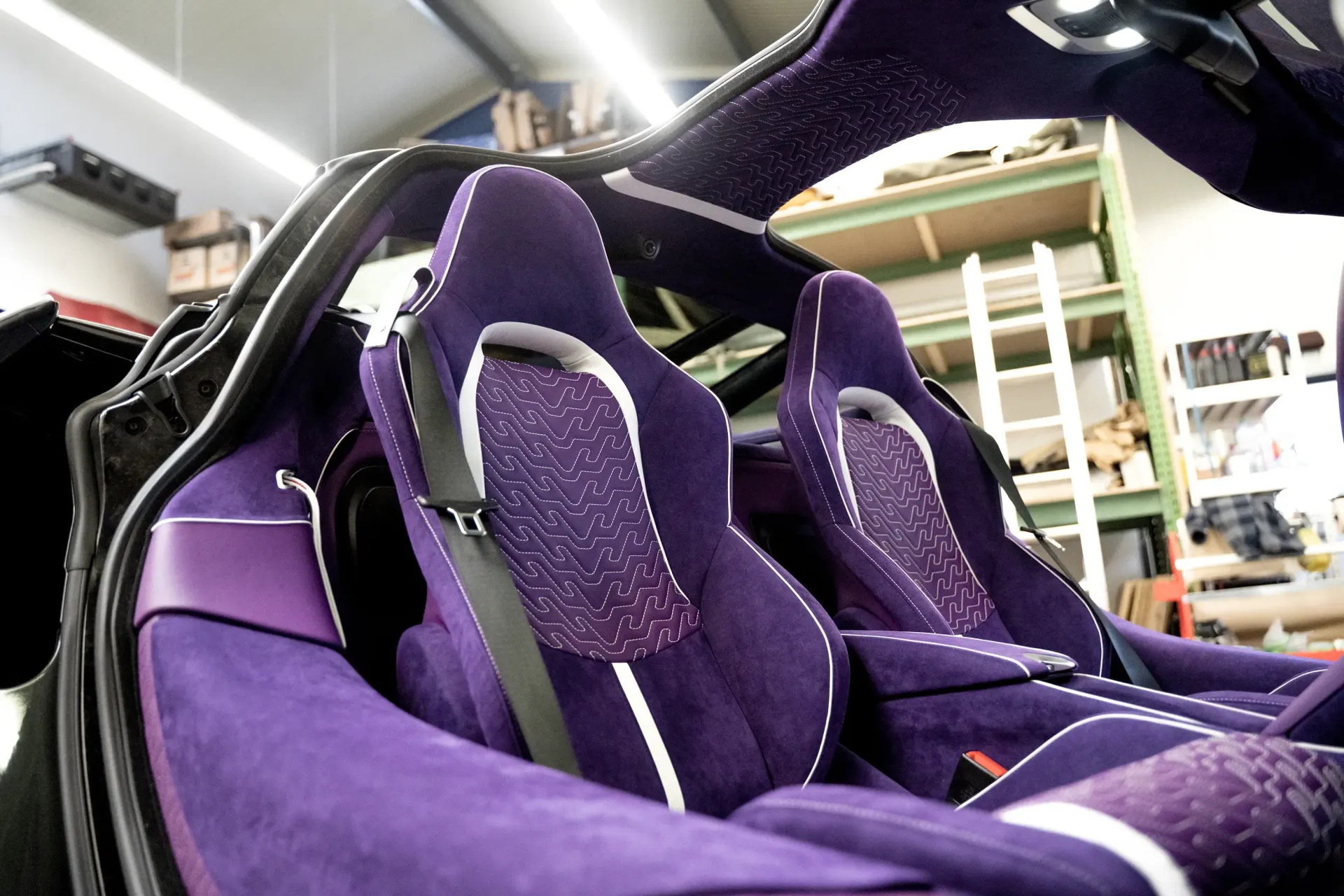 The inside of a purple sports car with purple seats, McLaren interior