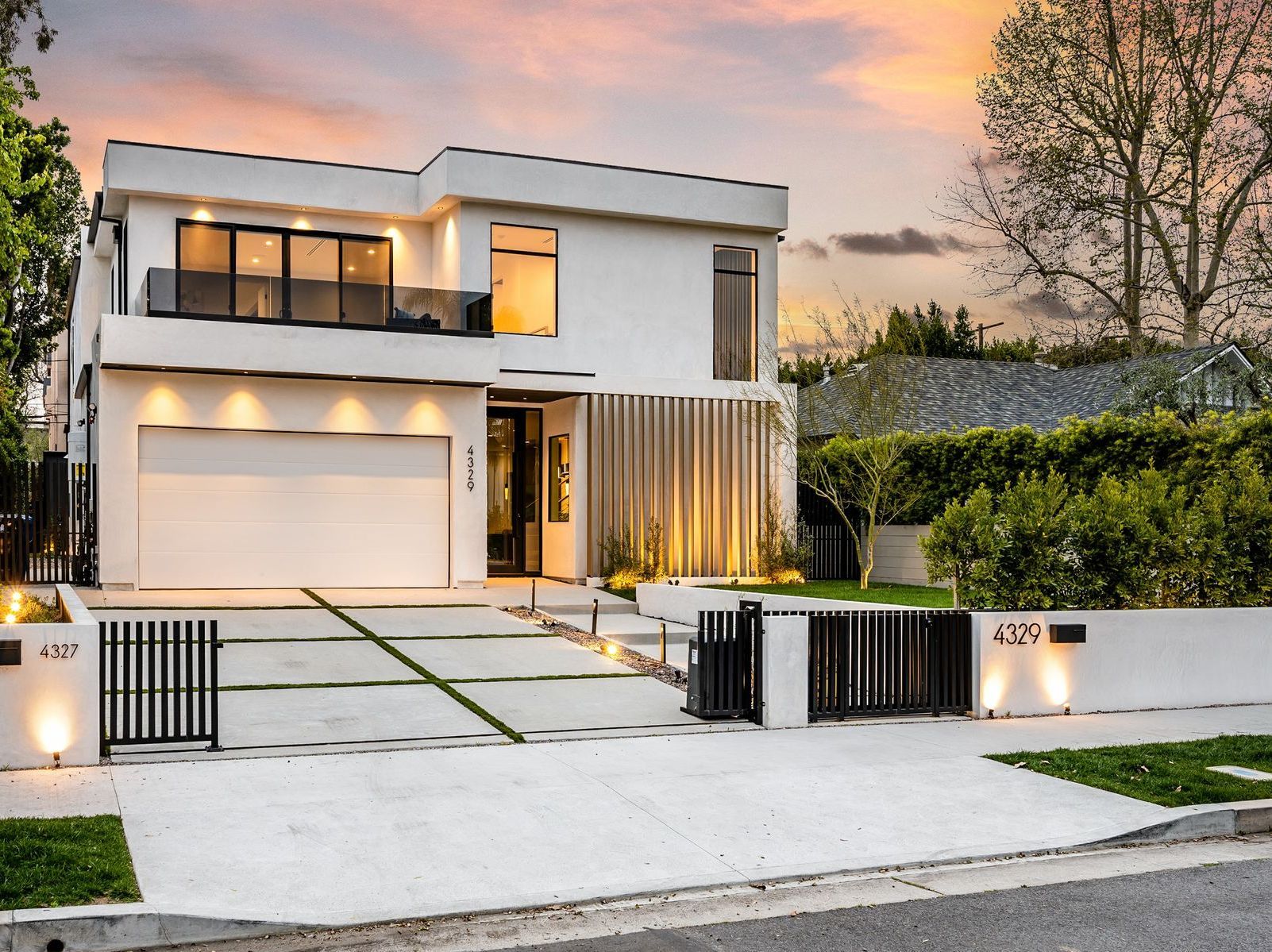 A large white house with a garage and a fence.