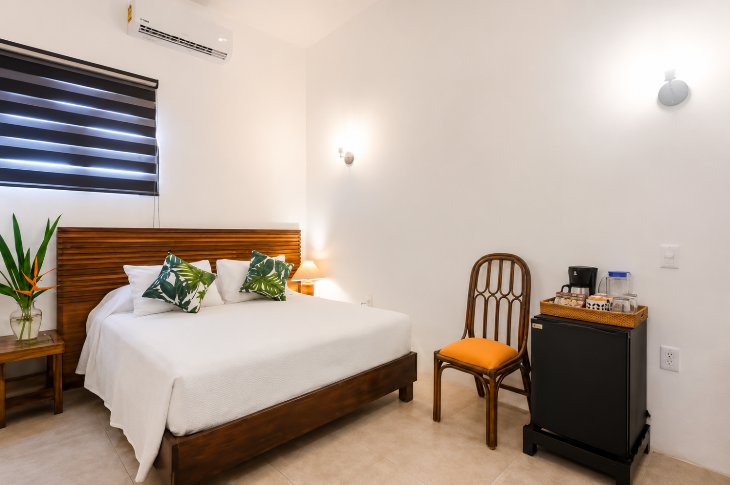 Small bedroom with a wooden bed, white bedding, chair, nightstand, and window blinds