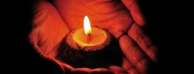Burning candle in hands